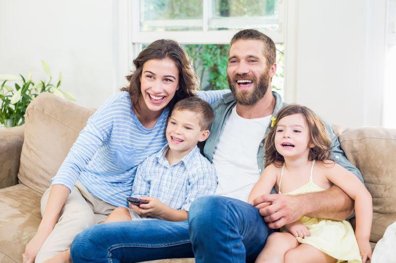 沙发上带着微笑的父母和孩子