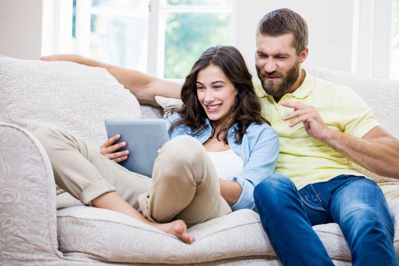 沙发上看平板的一堆新婚夫妇