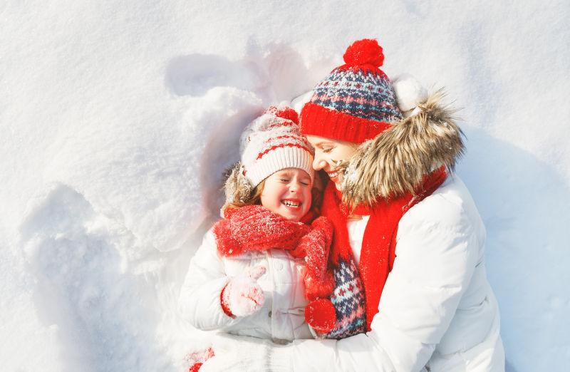 躺在雪地上玩的开心的母女