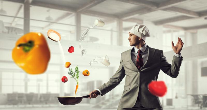 穿着西服带着厨师帽的商人拿着锅炒蔬菜