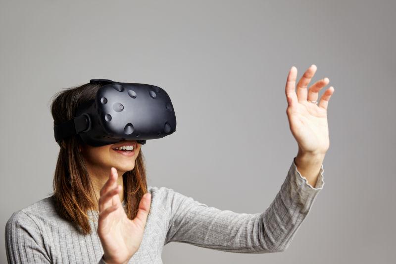 灰色背景下戴着3D眼镜-vr眼镜伸出手触摸物体的人