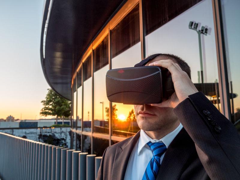 夕阳下在商业中心戴着3D眼镜-vr眼镜的商人