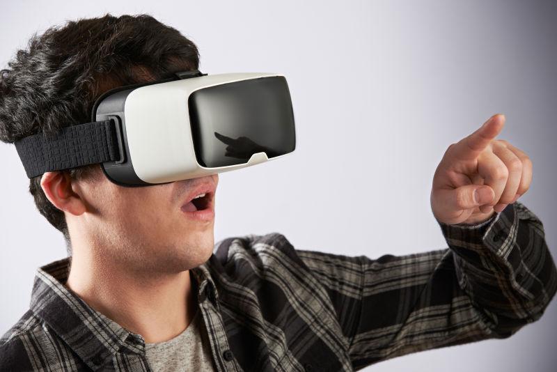 白色背景下戴着3D眼镜-vr眼镜伸出手指的年轻人