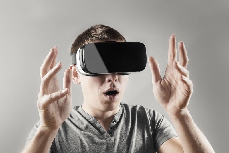 灰色背景下戴着3D眼镜-vr眼镜伸出双手的人