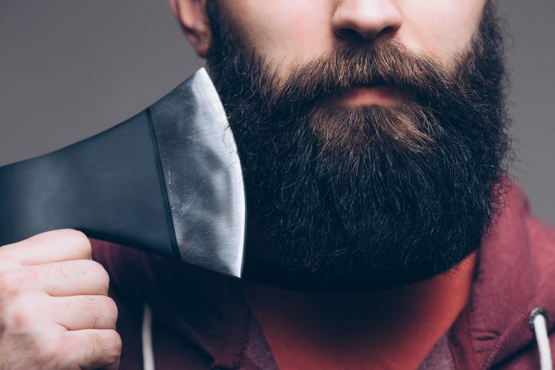 拿着一把大斧头的胡子男人