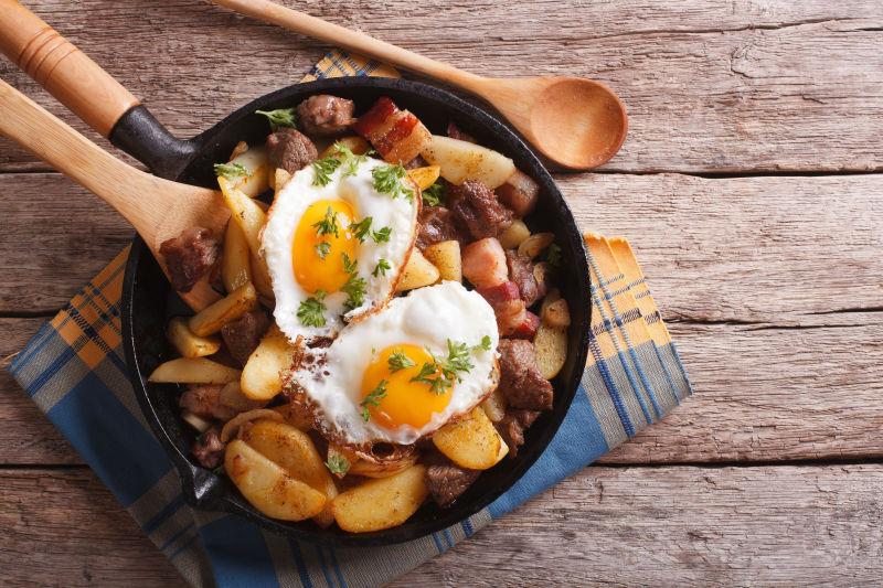 平底锅里的土豆炒肉和煎蛋