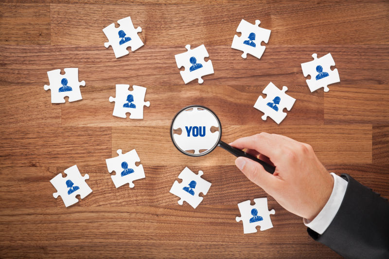 男人用放大镜看拼图