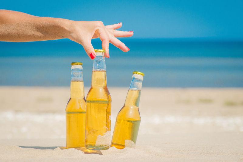 女人拿起了沙滩上的啤酒