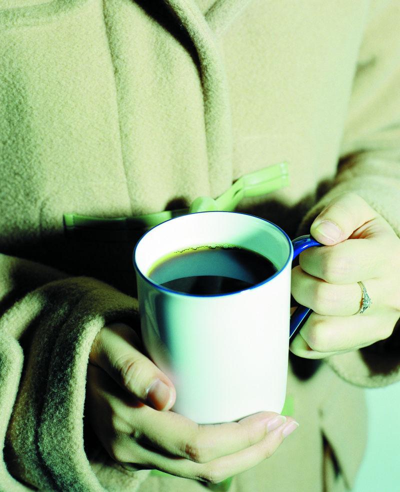 女人捧着一杯咖啡