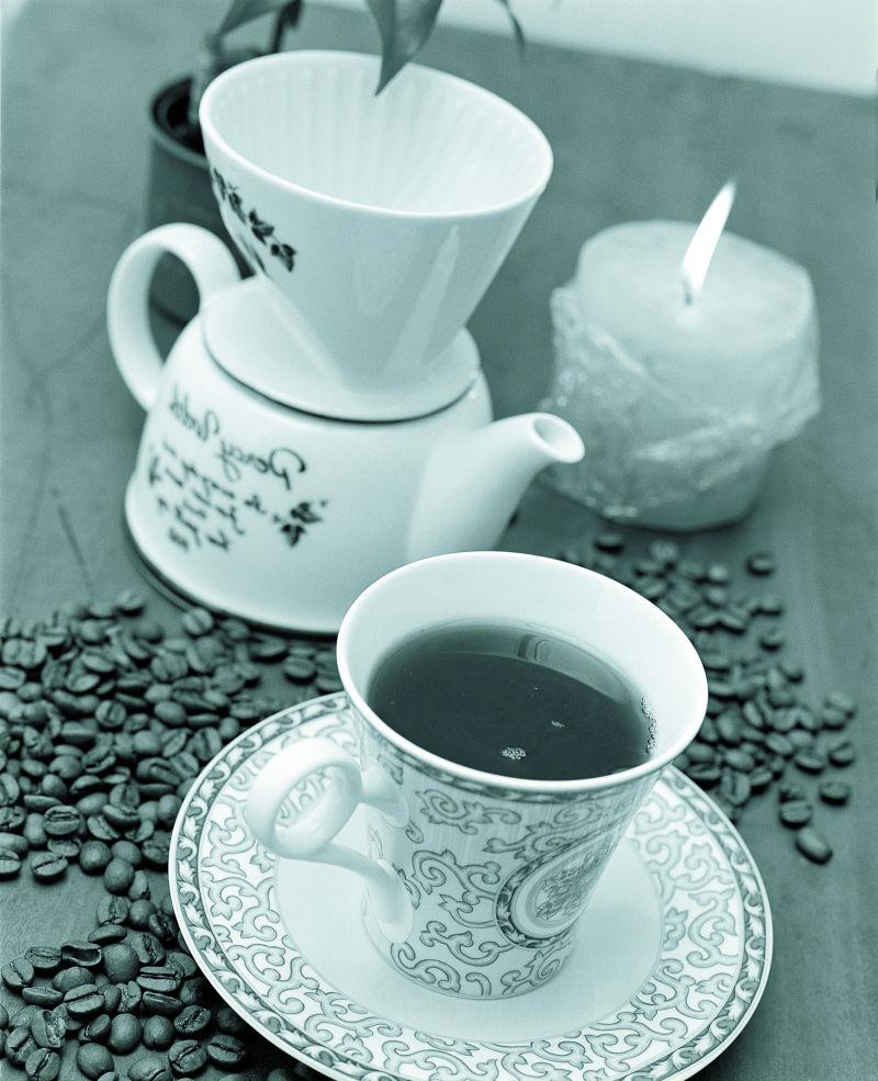 桌子上精致咖啡杯里的咖啡豆和咖啡