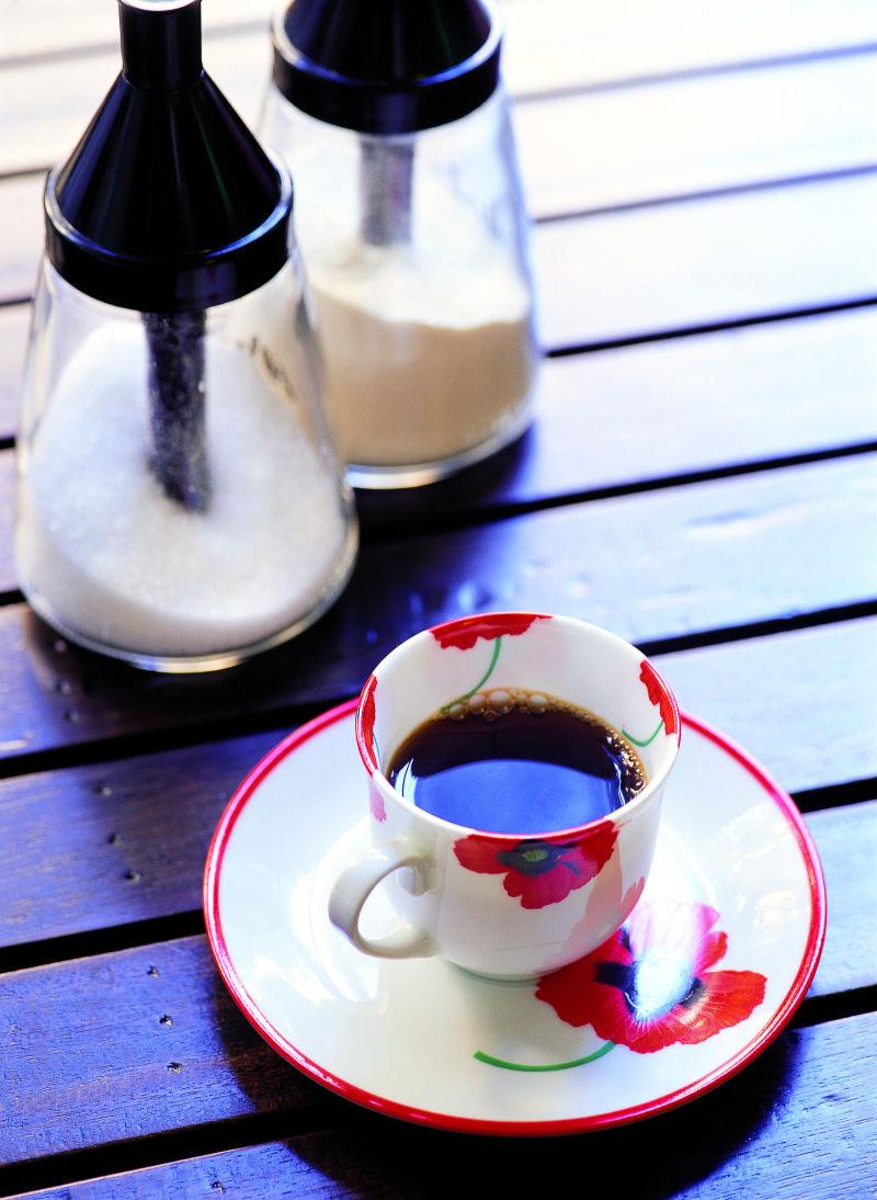 木桌上的一杯咖啡和糖