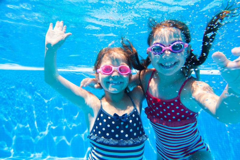 两个小女孩灵巧地在泳池里游泳