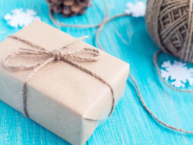 蓝色木桌上的牛皮纸礼盒和绑绳