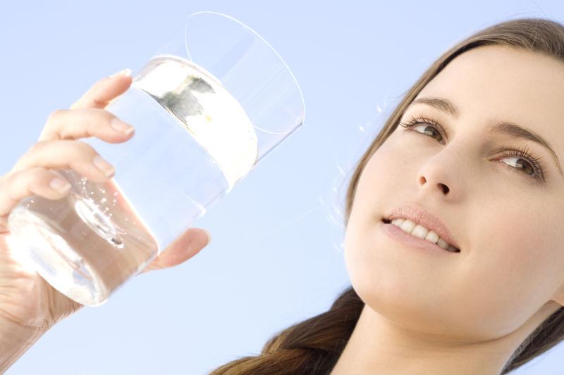 拿着玻璃杯的一个年轻女子