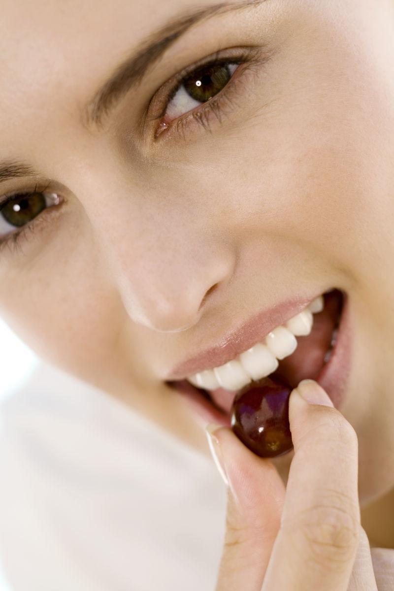 一个年轻女人在室内吃樱桃