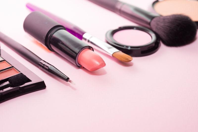 粉色背景中的化妆工具