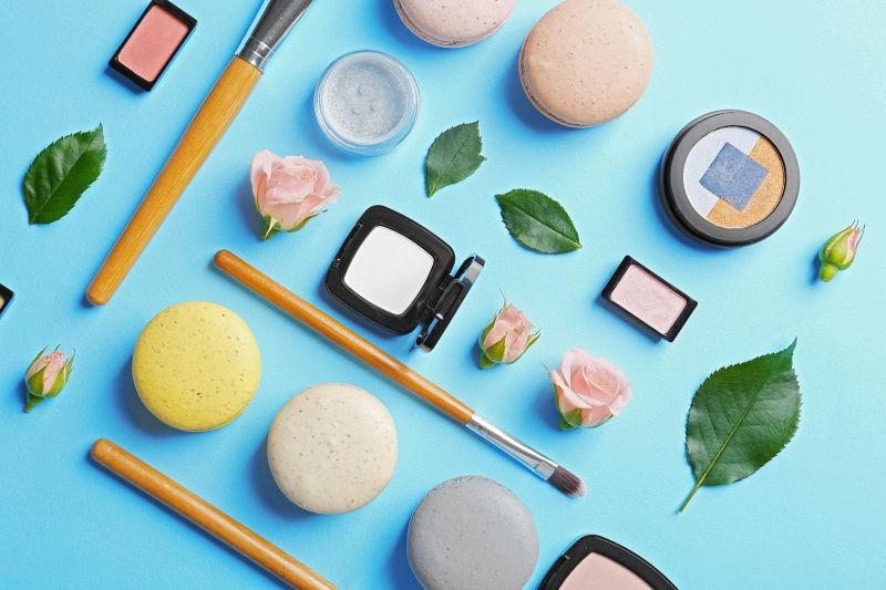 蓝色背景下的各种化妆粉底和化妆刷