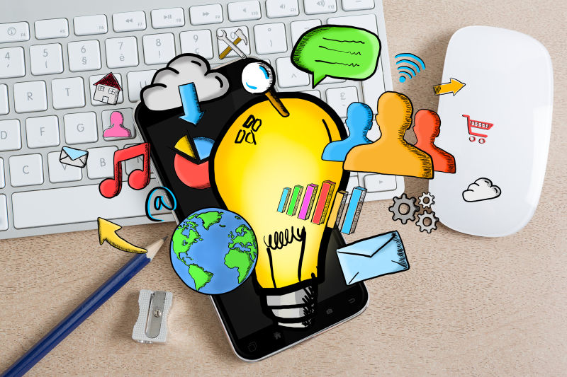 办公桌背景上的手绘灯泡和多媒体图标
