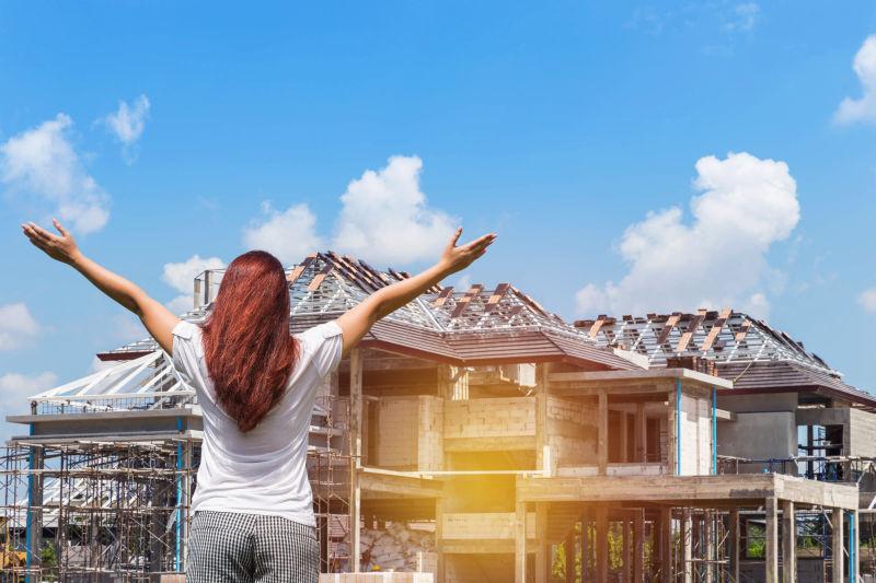 女人举起双手庆祝成功梦想中的新家