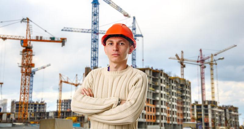 建筑和起重机背景下的建筑工人