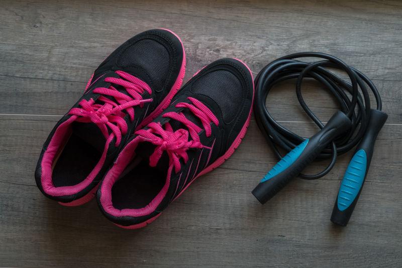 木质背景上的跳绳和运动鞋