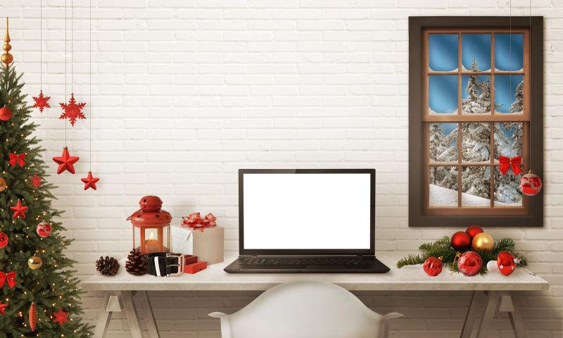 桌子上的笔记本电脑圣诞树和礼品