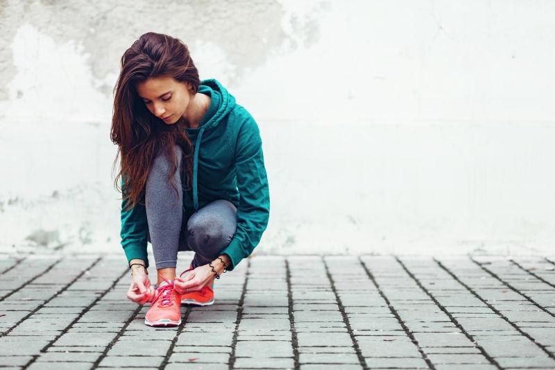在街头系鞋带的女孩