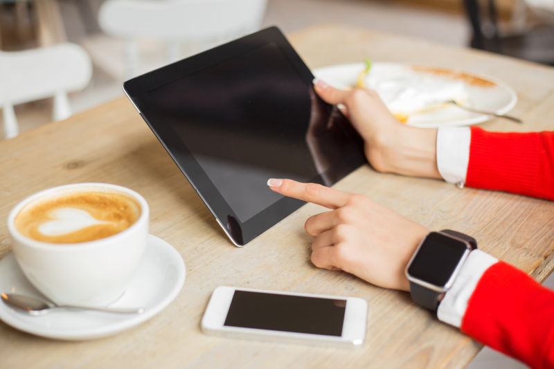 带着智能手表的男人在用平板电脑