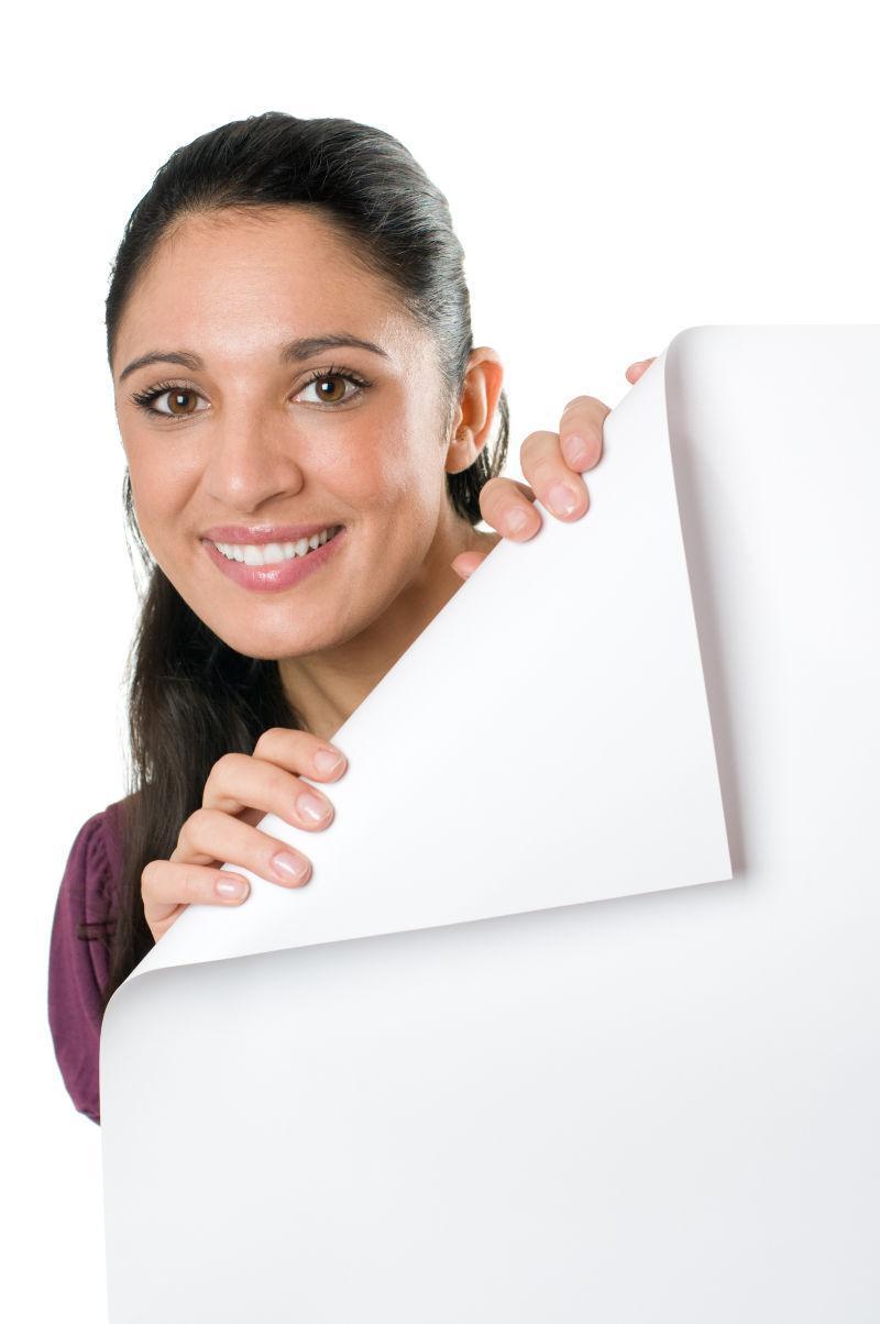 微笑的年轻女子拿着空白的招牌上的折叠角落