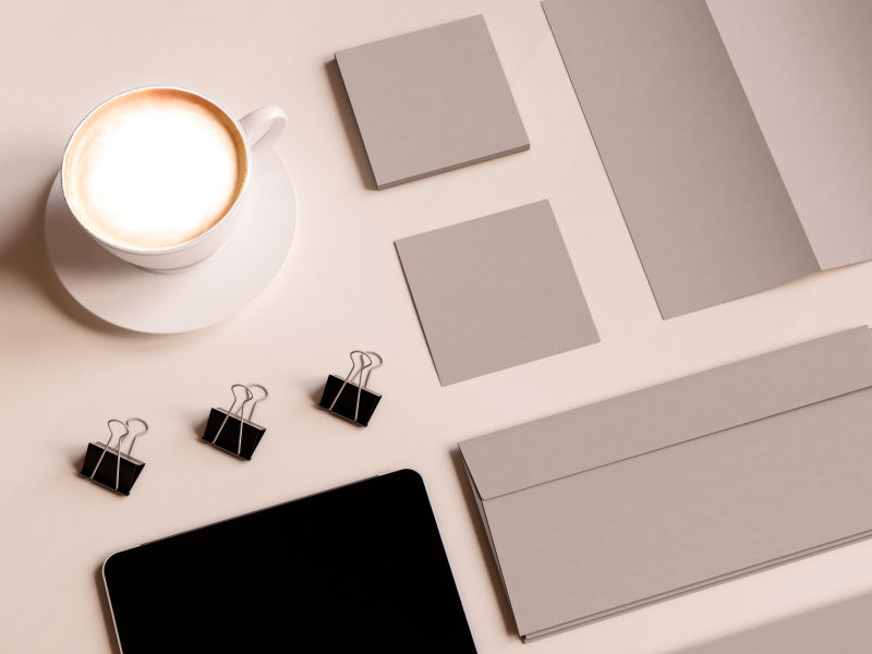 办公桌上的咖啡平板电脑空白纸张和夹子