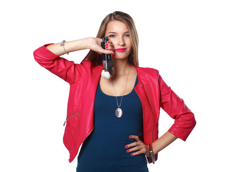 年轻美丽女子展示化妆刷