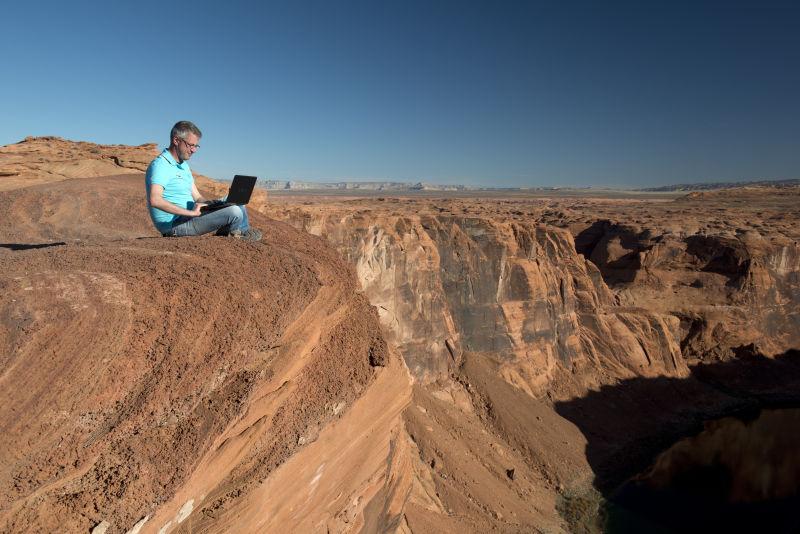 悬崖边正在办公的男人