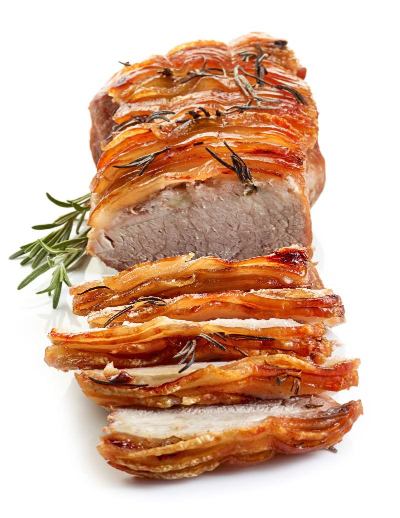 砧板上的切片猪肉和迷迭香