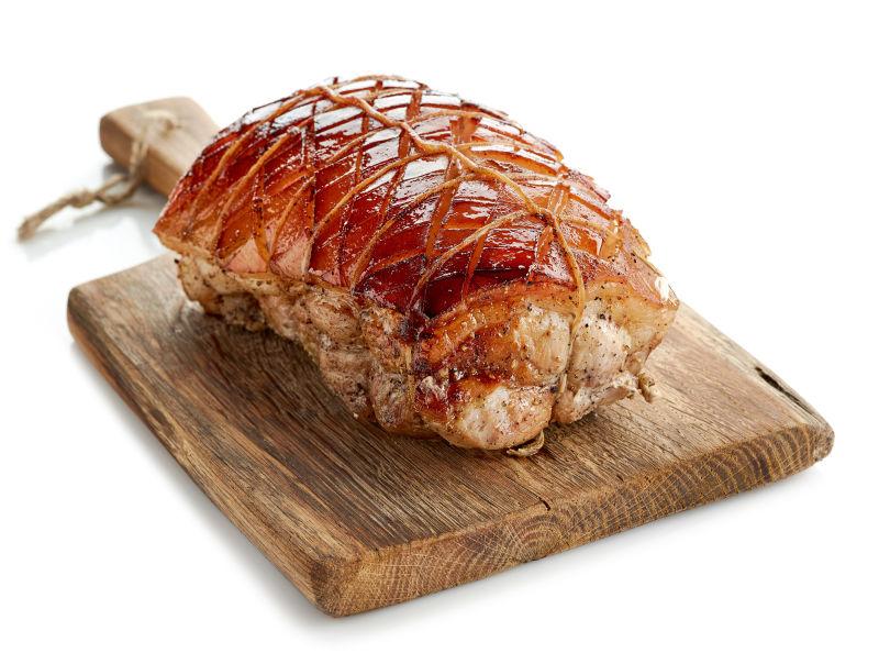 白色背景砧板上的烤猪肉