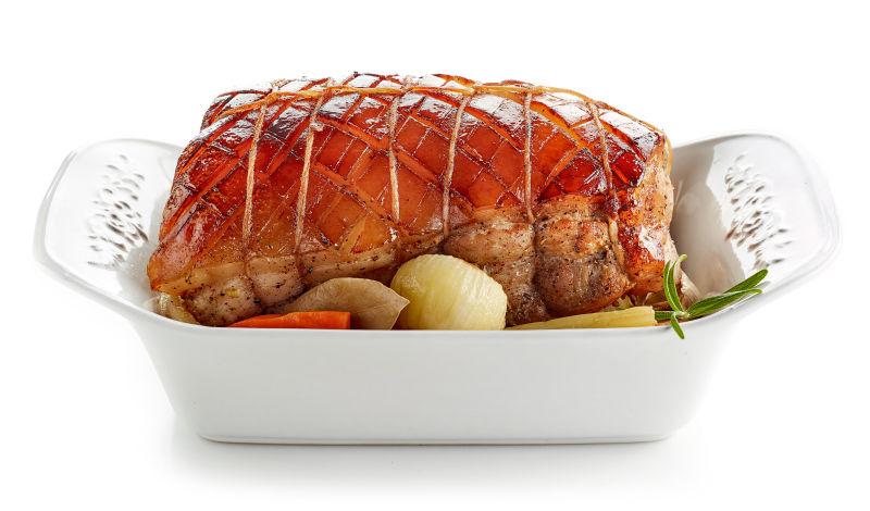 白色背景上盘子里的猪肉和蔬菜