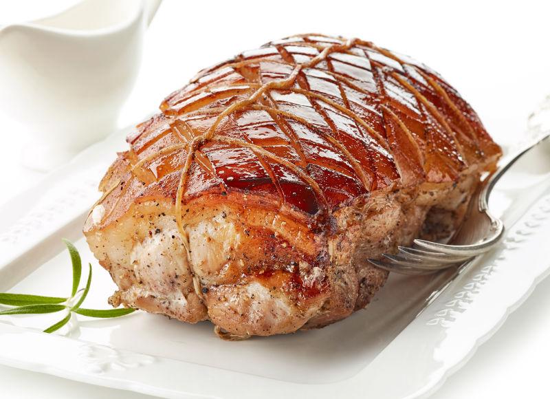 盘子里的烤猪肉和叉子