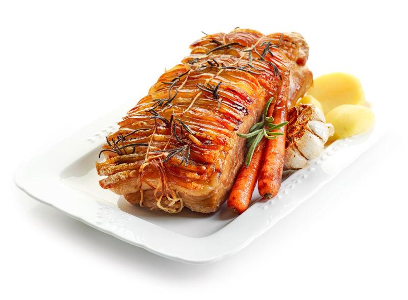 白色盘子里的蔬菜和烤猪肉