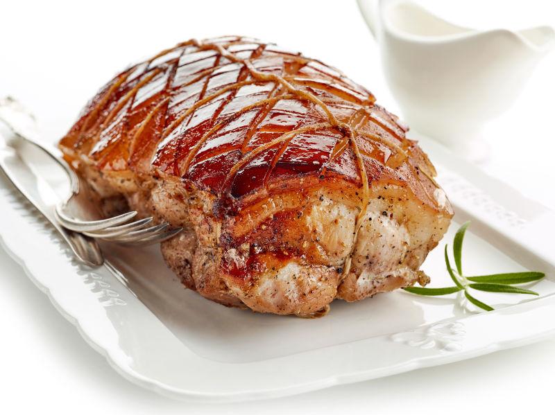 白色盘子里的一块烤猪肉