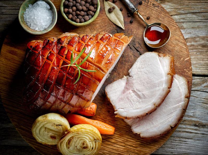 砧板上的烤猪肉片和蔬菜