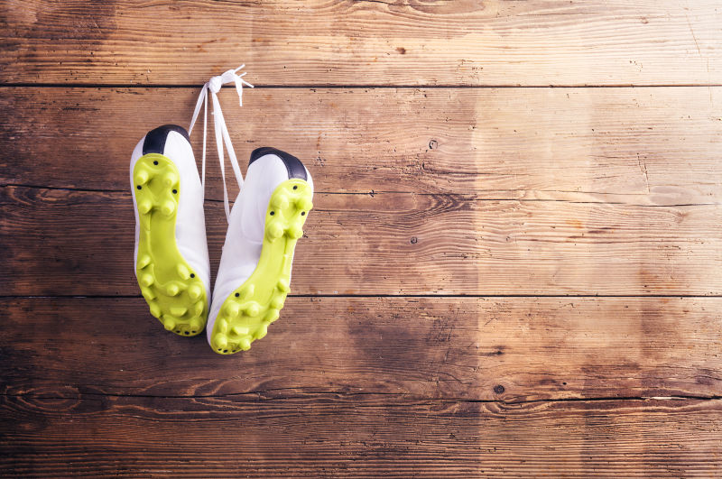 木质板上黄色鞋底的运动鞋