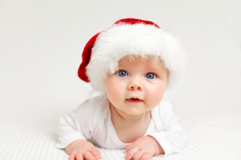 床上戴圣诞帽的小婴儿