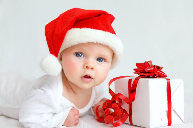 床上带圣诞老人帽子的小婴儿