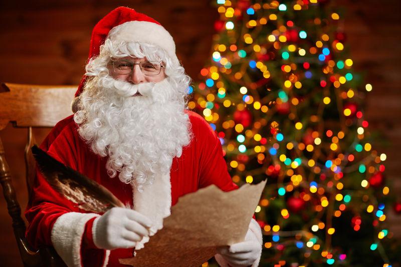 圣诞老人坐在椅子上看着报纸