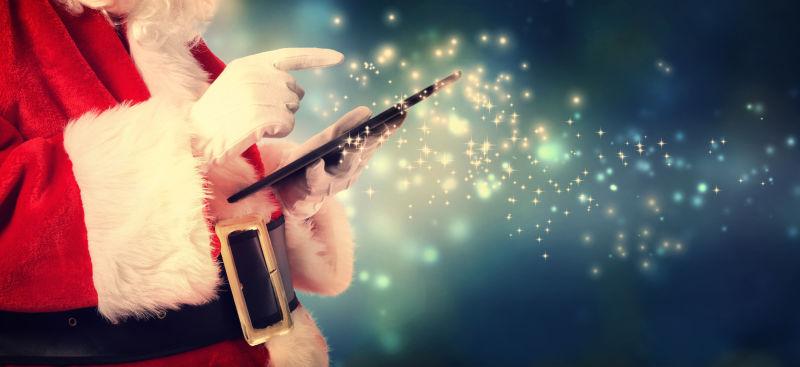 圣诞老人在雪夜拿着平板电脑