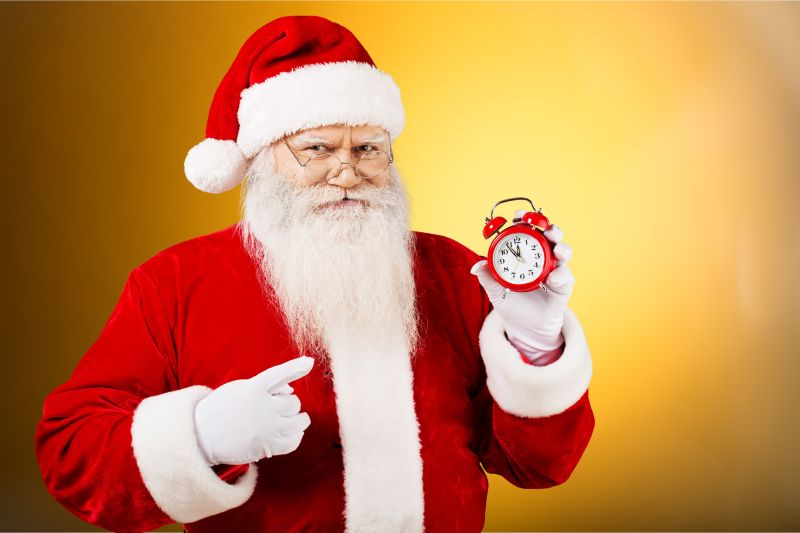 圣诞老人指着闹钟微笑