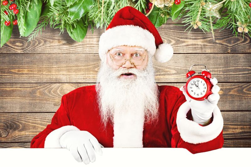 圣诞老人拿着红色的闹钟