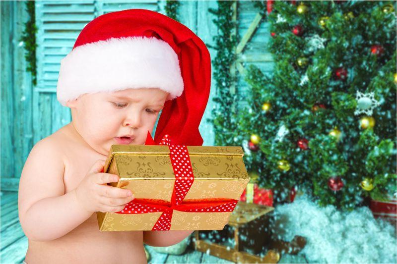 戴着圣诞帽的婴儿拿着礼物