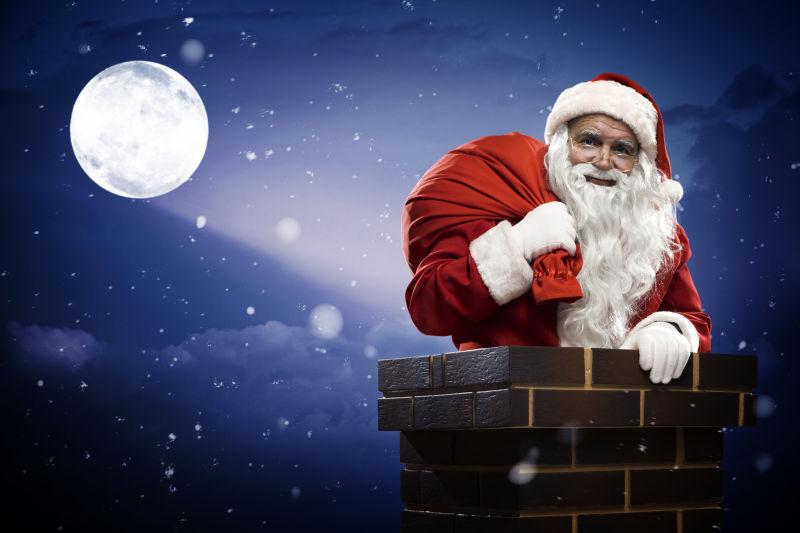 在夜晚的圣诞老人拿着圣诞礼物