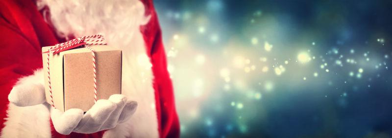 圣诞老人手里拿着一件礼物