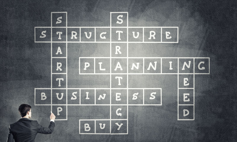 写满单词的黑板下有一个穿着西服的商人